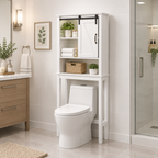 A white bathroom wall-mounted storage cabinet with a sliding barn-style door and open shelves, shown above a toilet in a bright, modern bathroom.