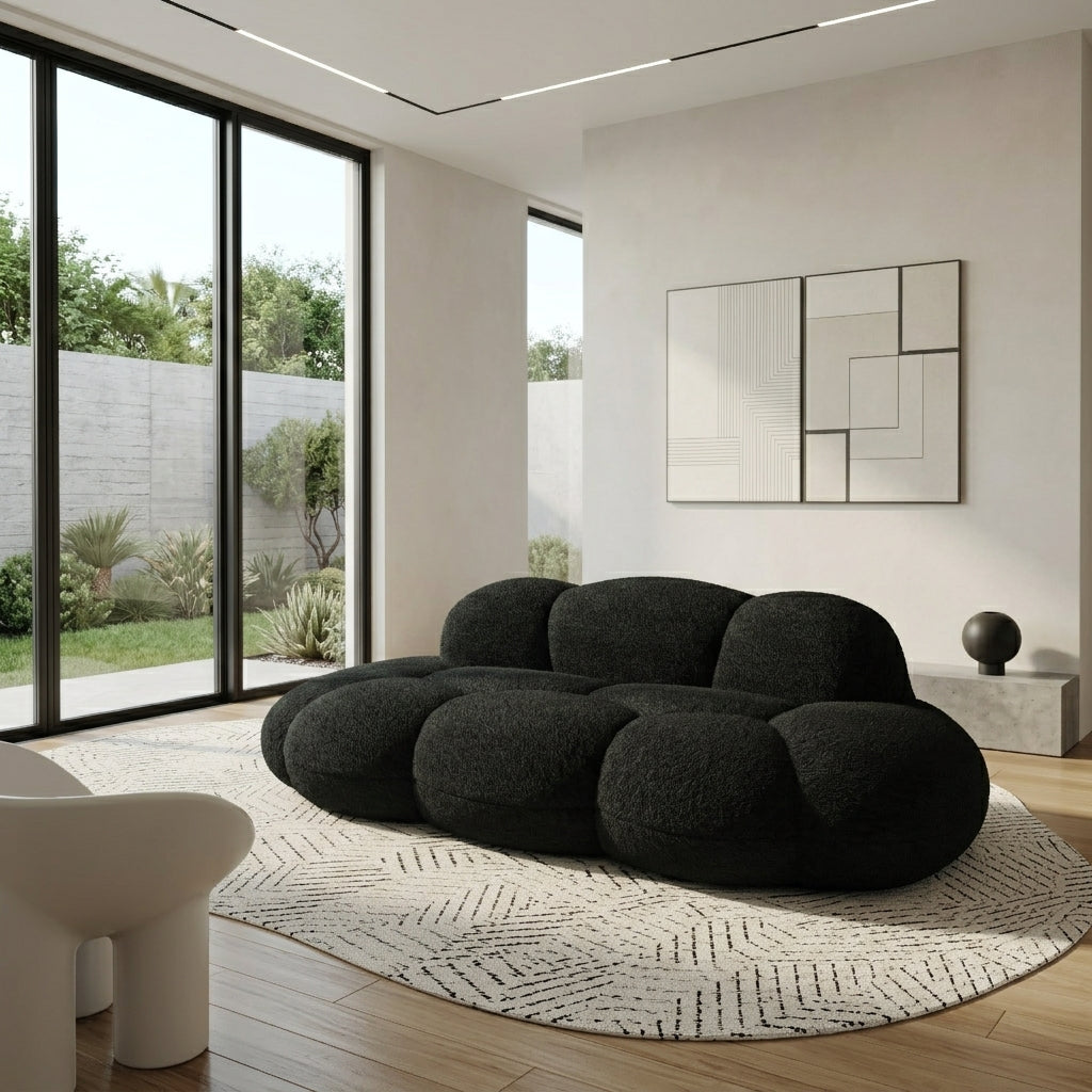 Black boucle cloud sofa with rounded bubble cushions on a round rug in a modern living room