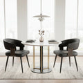 Dining room with a round table and black chairs, featuring a modern light fixture and abstract art on the wall.