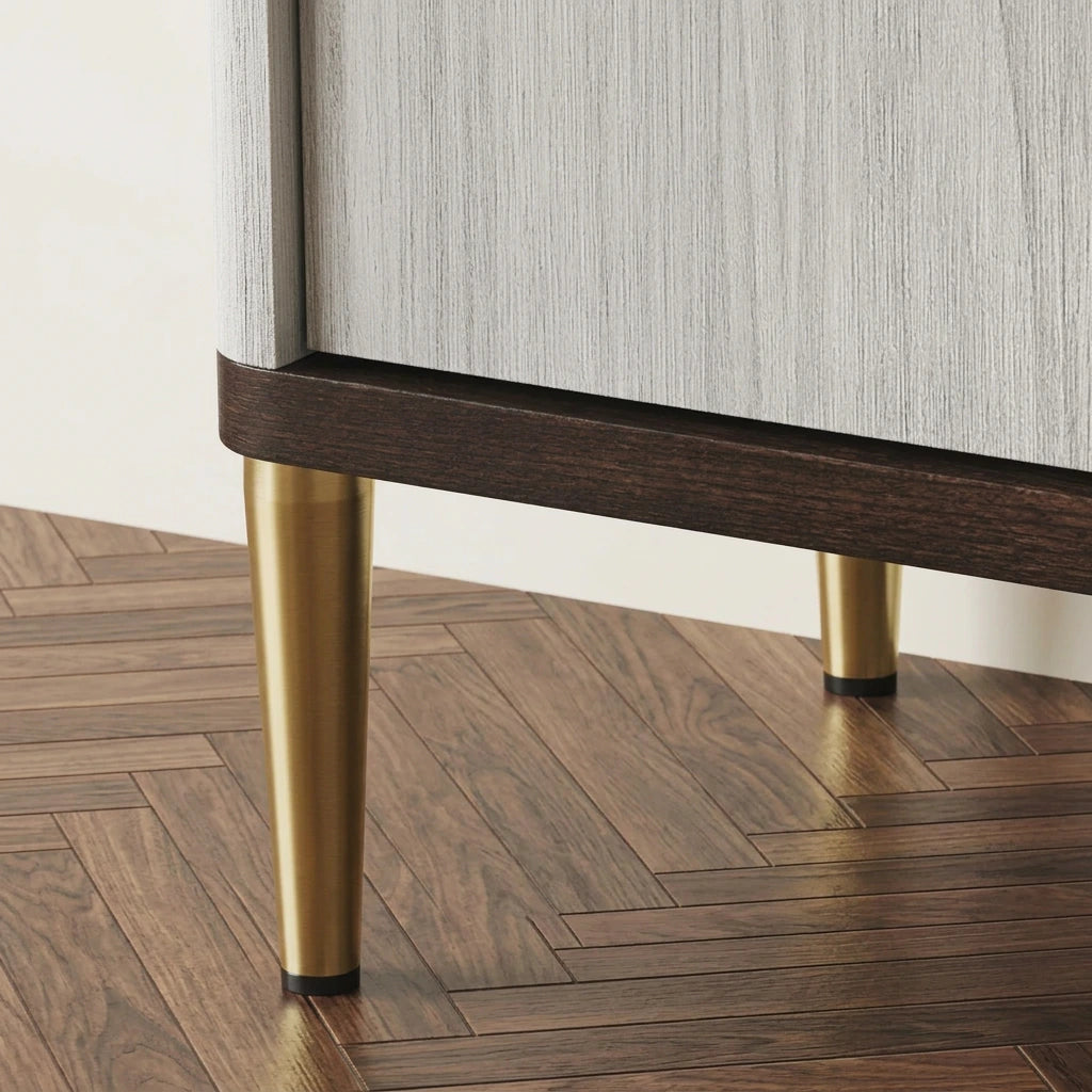 Close-up of gold tapered metal legs under the white and walnut sideboard