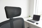 Black office chair with mesh backrest in a room with furniture and decor.