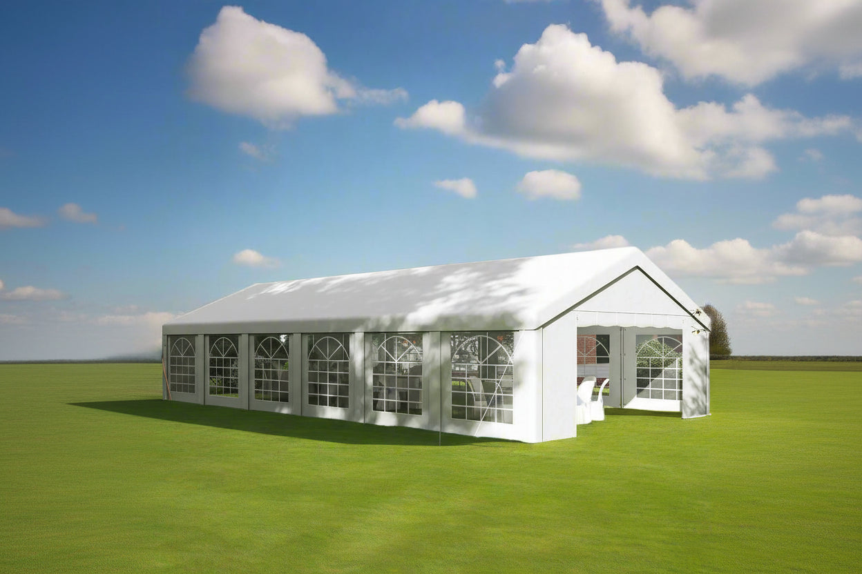 Large white outdoor tent with glass panels on a grassy area under a blue sky.